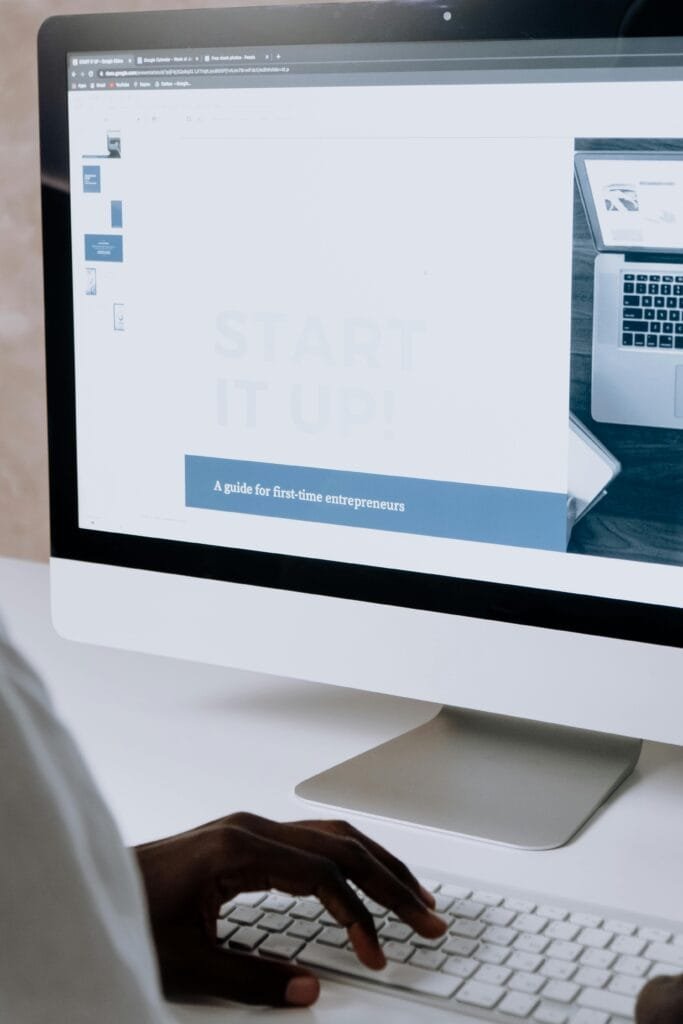 Person working on a website design for first-time entrepreneurs on a desktop computer.